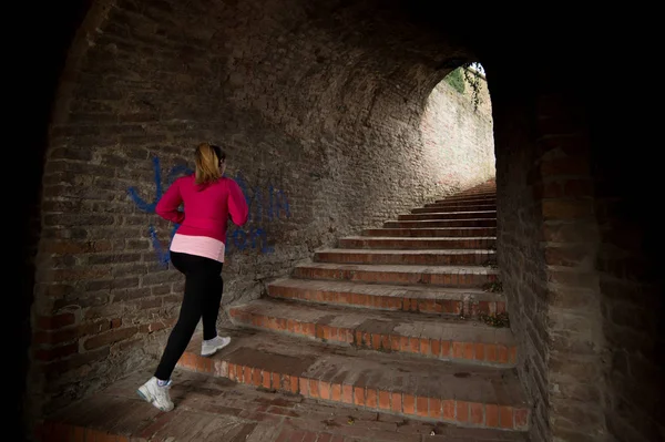 Chica vistiendo ropa deportiva y corriendo escaleras abajo en la fortaleza de la ciudad —  Fotos de Stock