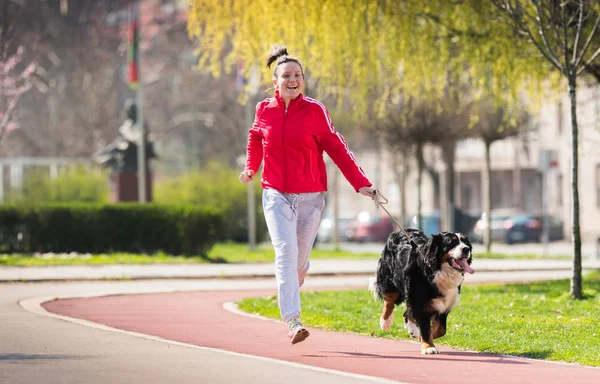 Mooi meisje lopen buiten met haar Berner Sennenhond — Stockfoto