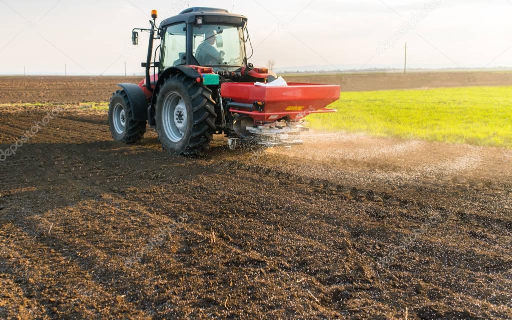 Tractor spreading artificial fertilizers  