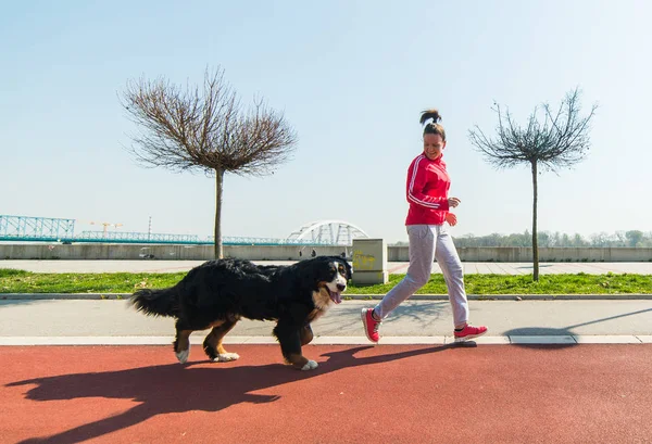 Mooi meisje lopen buiten met haar Berner Sennenhond — Stockfoto