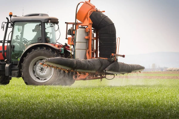 Trator pulverizando pesticida no campo de trigo com pulverizador — Fotografia de Stock