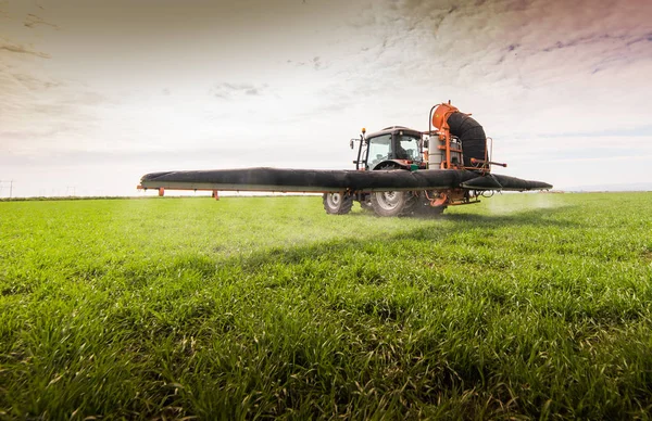 Пестицид трактора на пшеничном поле с распылителем — стоковое фото