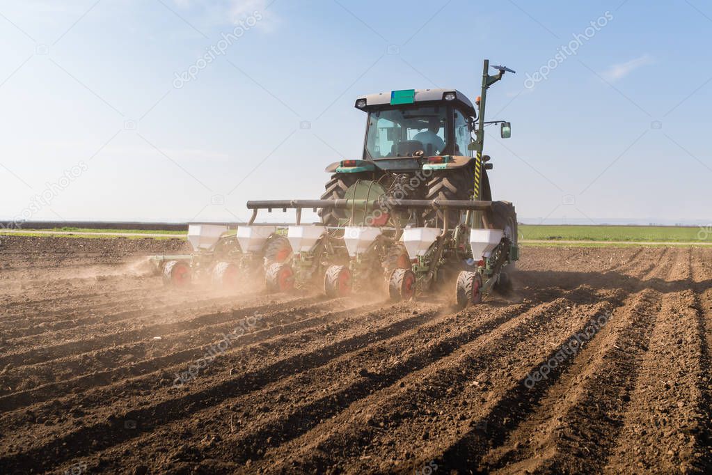 Farmer with tractor seeding - sowing soy crops at agricultural f