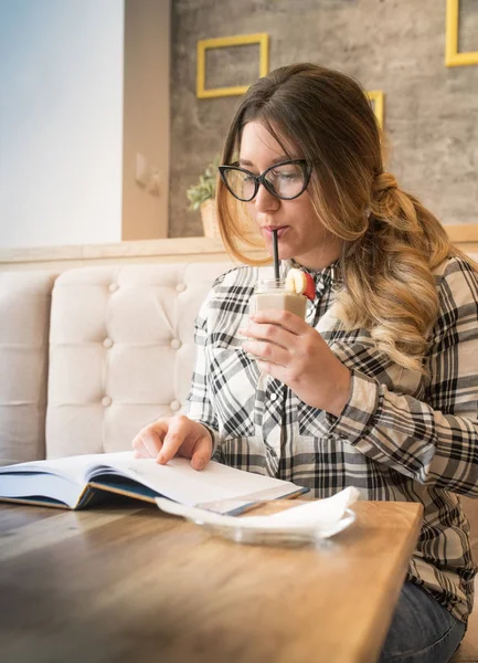 Ładna dziewczyna w okularach picia koktajl truskawkowy bannana — Zdjęcie stockowe