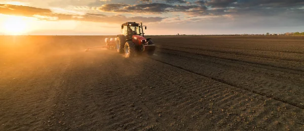 Farmář s traktorem sešlost - setí plodin na zemědělské oblasti — Stock fotografie