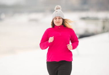 Spor giyim giymek ve kış aylarında kar üzerinde çalışan güzel kız