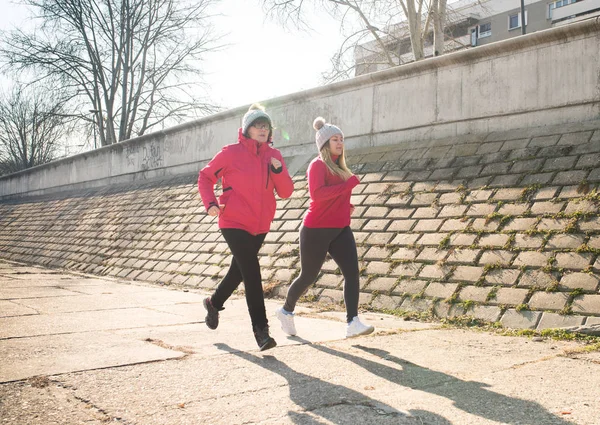 Mutter und Tochter tragen Sportbekleidung und laufen an windigen Tagen — Stockfoto