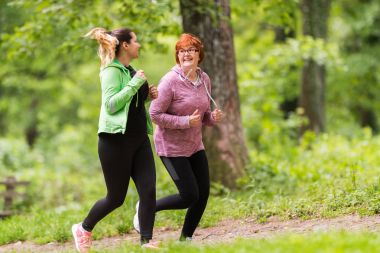 Anne ve kızı spor giyim giymek ve orman çalıştırmak için 