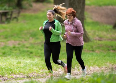 Anne ve kızı spor giyim giymek ve orman çalıştırmak için 