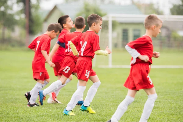 Fútbol infantil - niños jugadores haciendo ejercicio antes del partido —  Fotos de Stock