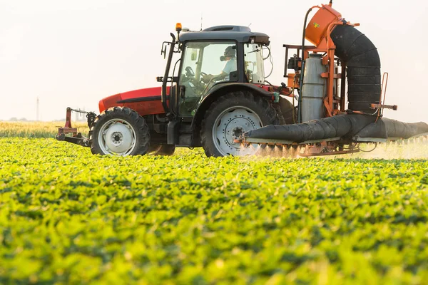 Traktor sprutning sojabönor fältet på våren — Stockfoto