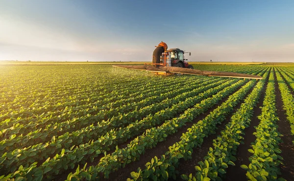 Traktor sprutning sojabönor fältet på våren — Stockfoto