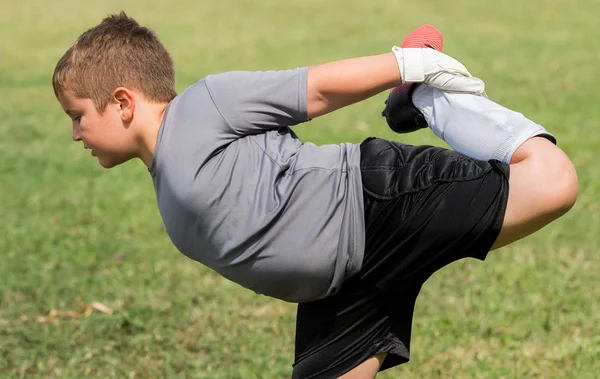 Kids soccer football - little goalkeeper is stretching before so — Stock Photo, Image
