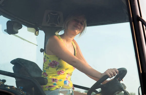 美丽、 年轻的农夫女孩驾驶拖拉机 — 图库照片