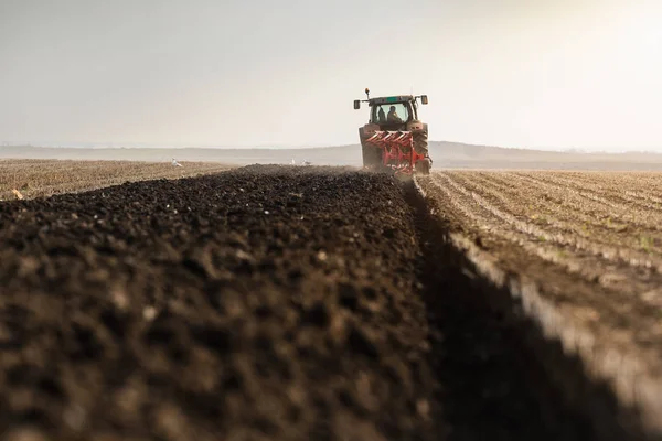 Traktor plöjer fälten - förbereda marken för sådd — Stockfoto