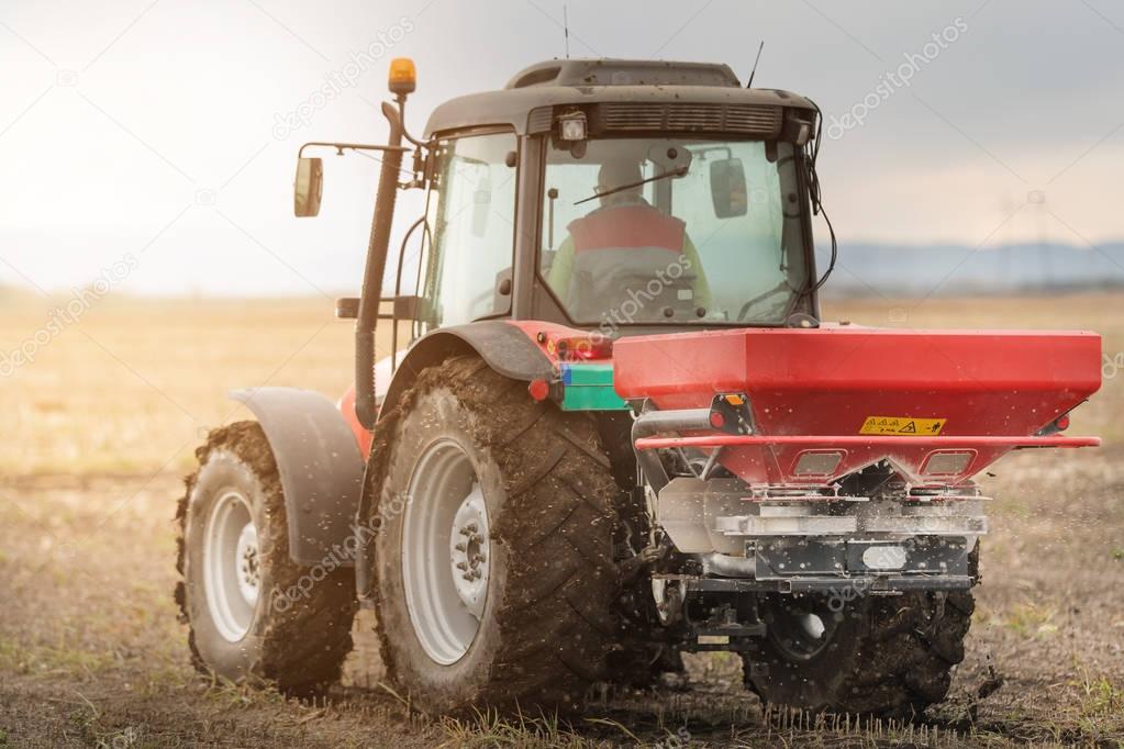 Tractor spreading artificial fertilizers  