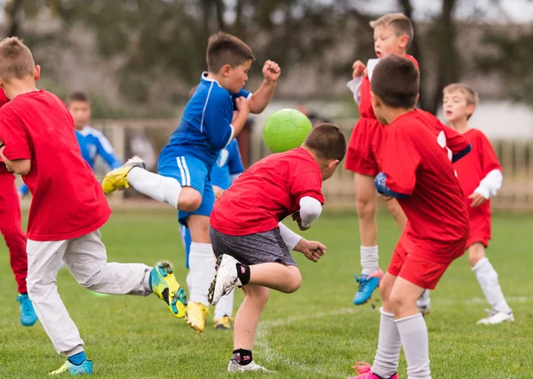Fiatal gyerekek játékos labdarúgó-mérkőzés futballpályán — Stock Fotó