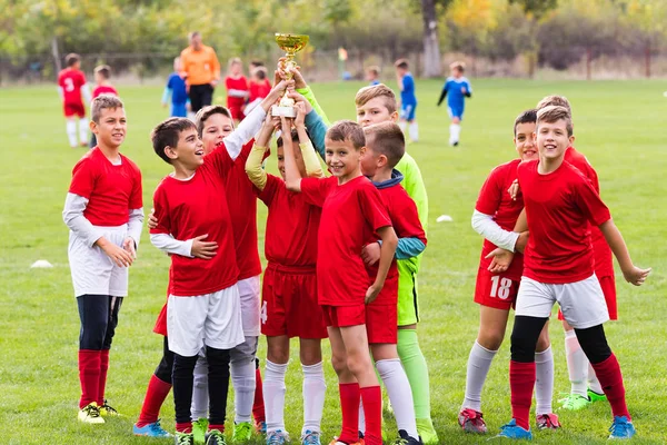 Děti fotbal fotbal - děti hráči slaví s trop — Stock fotografie