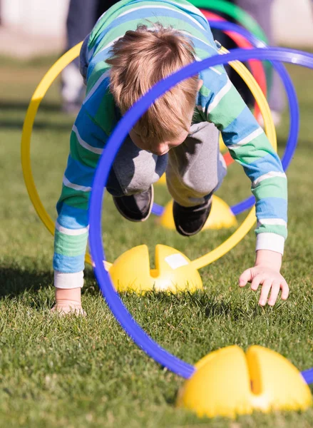 Child playing in a exercising circle - tunnel tube, crawling thr — Stock Photo, Image