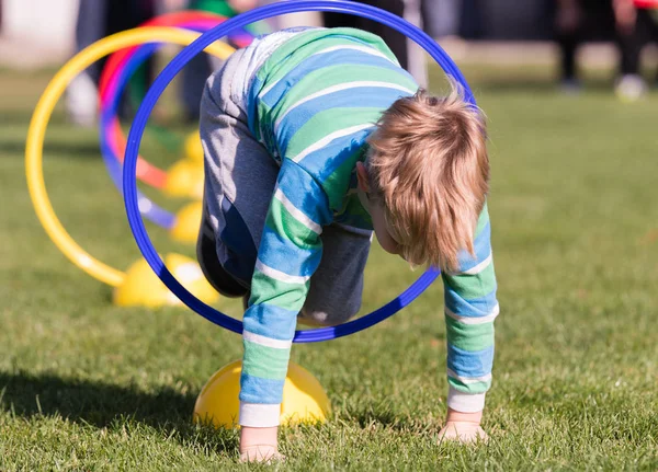 Niño jugando en un círculo de ejercicio - tubo de túnel, arrastrándose thr —  Fotos de Stock