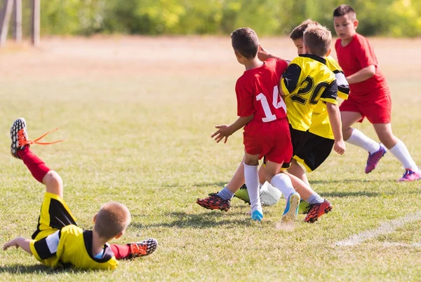 Fiatal gyerekek játékos labdarúgó-mérkőzés futballpályán — Stock Fotó