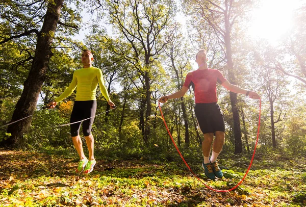 Handsome young men wearing sportswear and exercising in forest a — Stock Photo, Image