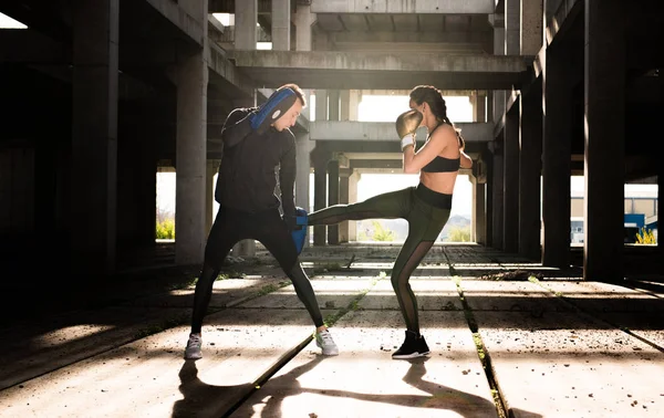 年轻的运动员夫妇做踢拳击运动在一个老 aband — 图库照片