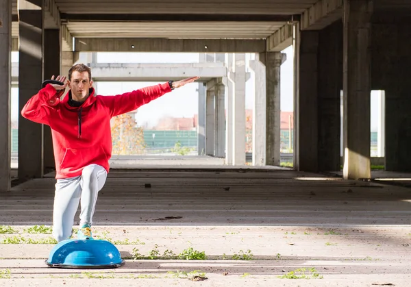 Young handsome athlete men doing exercise  in an old abandoned b — Stock Photo, Image