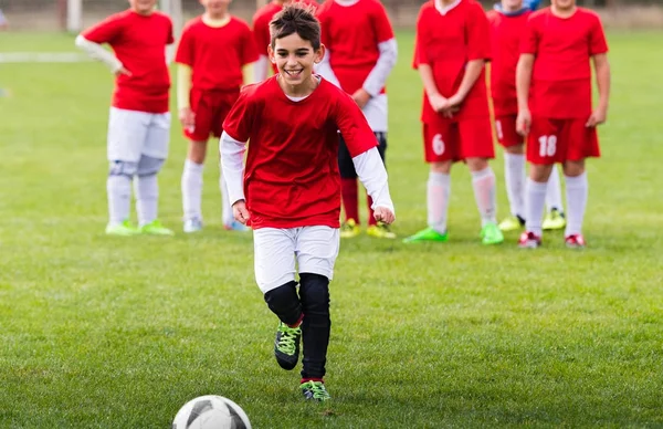 Junge kickt Fußball auf dem Sportplatz — Stockfoto