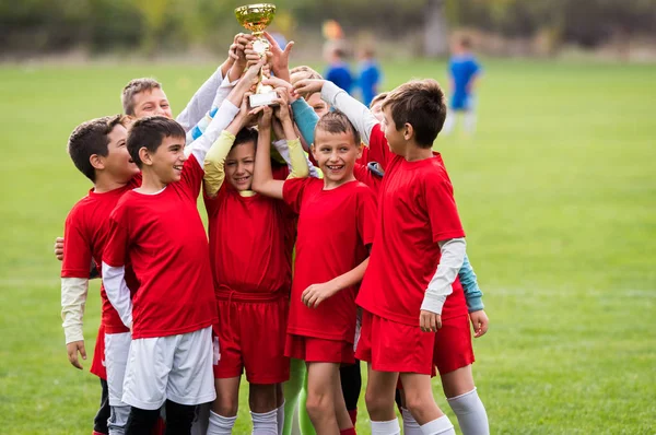 Kinderen voetbal voetbal - kinderen-spelers vieren met een trop — Stockfoto