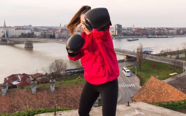 Genç kız boks eldivenli bir yumruk - dövüş sanatları atma — Stok fotoğraf