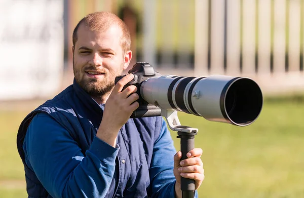 Fotógrafo sosteniendo la cámara en el stand — Foto de Stock