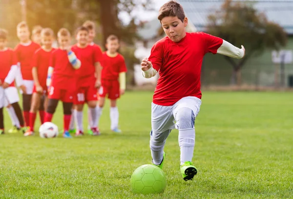 Jongen schoppen Voetbal op het sportveld — Stockfoto