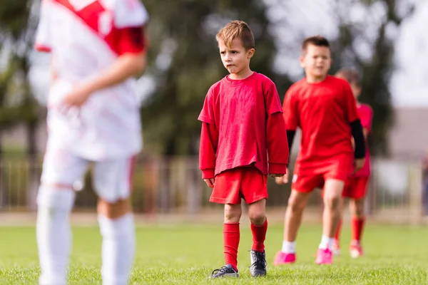Unga barn spelare fotbollsmatch på fotbollsplan — Stockfoto