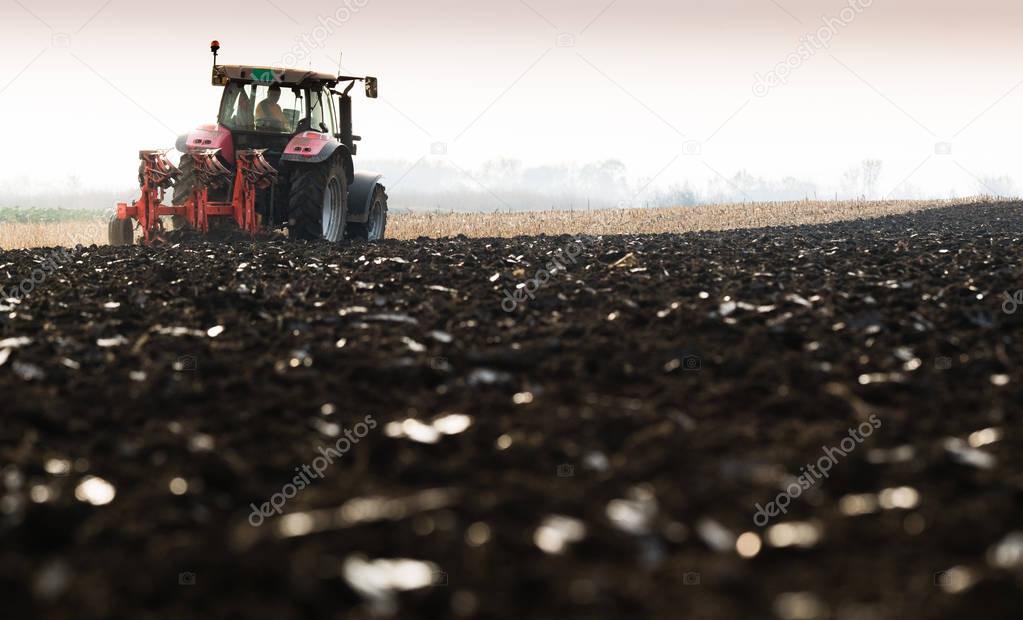 Tractor plowing fields -preparing land for sowing in autumn