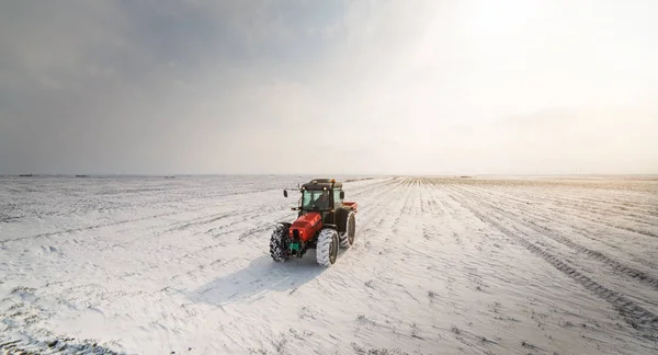 Farmer with tractor seeding - sowing crops at agricultural field