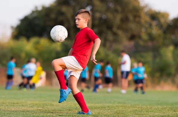Junge kickt Fußball auf dem Sportplatz — Stockfoto