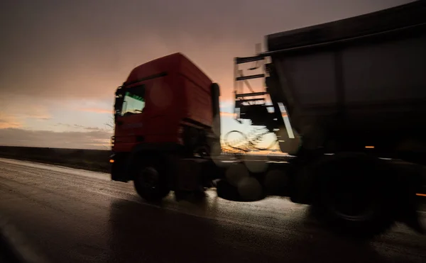 Passeio noturno - caminhão em movimentos durante o pôr do sol — Fotografia de Stock