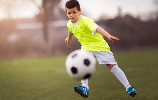 Junge kickt Fußball auf dem Sportplatz — Stockfoto