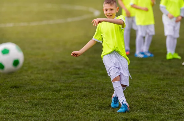 Junge kickt Fußball auf dem Sportplatz — Stockfoto