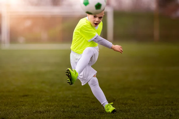 Ragazzo calci calcio sul campo sportivo — Foto Stock