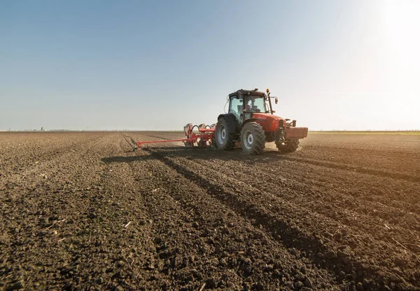 Agricultor con siembra de tractores - siembra de cultivos en el campo agrícola — Foto de Stock