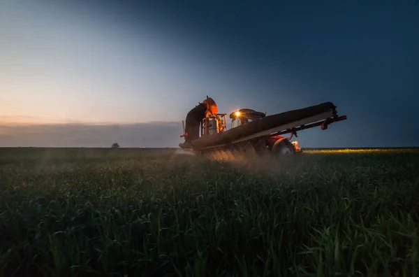 Trator pulverizando pesticidas no campo de trigo com pulverizador no sunse — Fotografia de Stock