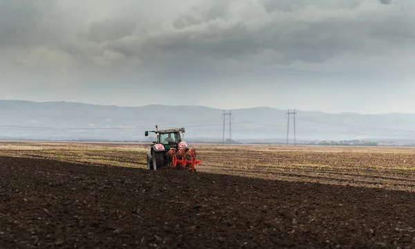 Tractor ploegen velden bij zonsondergang — Stockfoto