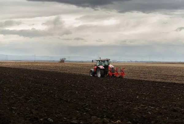 Tractor ploegen velden bij zonsondergang — Stockfoto