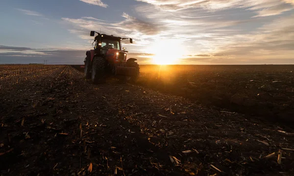 Tractor ploegen velden bij zonsondergang — Stockfoto