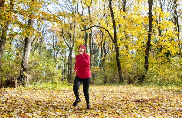 Middle age woman wearing sportswear and running in forest. — Stock Photo, Image