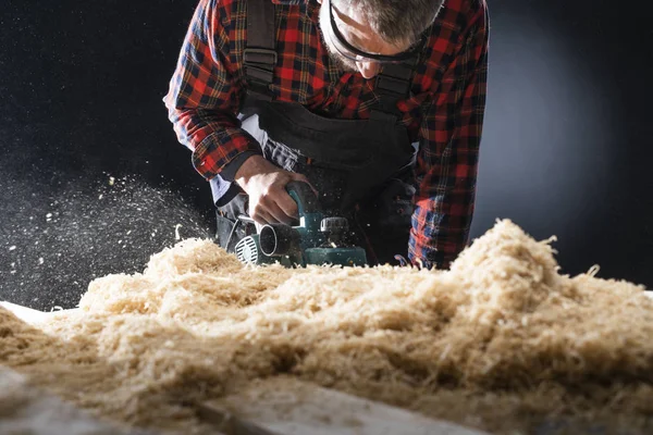 Tablón de madera cepillado con un plano eléctrico . — Foto de Stock