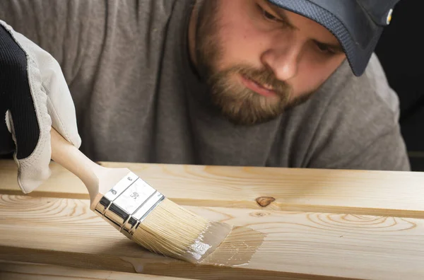 Hand aus nächster Nähe Pinselfarbe Klarlack auf Holzoberfläche verwenden. — Stockfoto