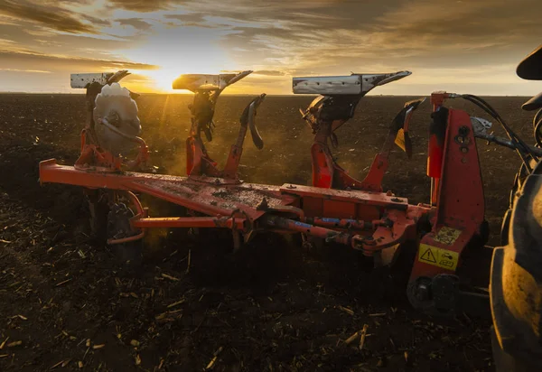 Campi di aratura del trattore al tramonto — Foto Stock